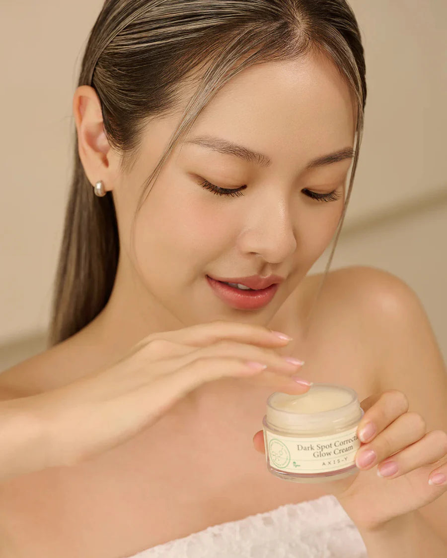 Image of a model holding a jar of the Axis-Y Dark Spot Correcting Glow Cream.